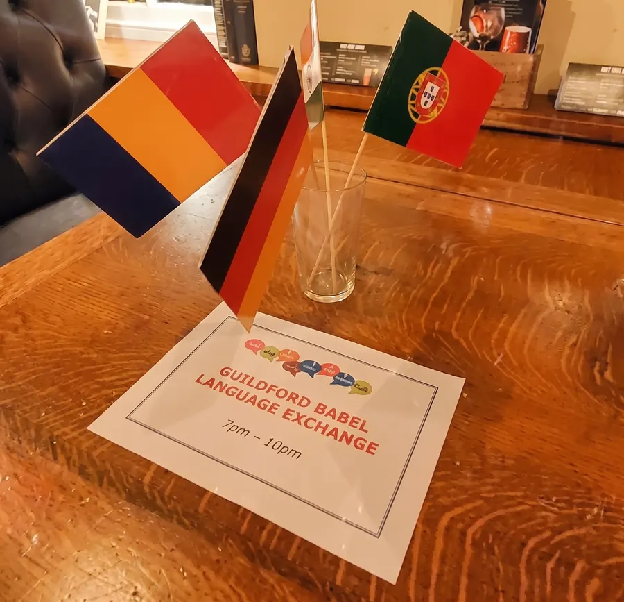 Table flags and a Guildford Babel Language Exchange sign on a pub table