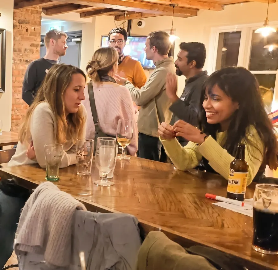 People laughing and chatting at the bar at a Guildford Babel evening